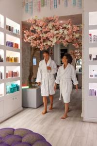 twee vrouwen in witte gewaden lopen in een salon bij Cloud 9 Boutique Hotel and Spa in Kaapstad