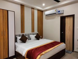 a bedroom with a bed with a air conditioner on the wall at Royal Rooms and Banquet in Lucknow
