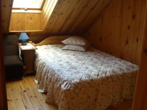 sypialnia z łóżkiem, krzesłem i oknem w obiekcie Kučuru dzirnavas w mieście Lautere