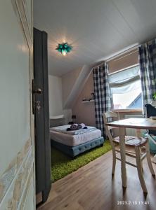 ホンブルクにあるFerienwohnung Beeden - zur Glasschmiedeのベッドルーム1室(ベッド1台、テーブル、テーブル、椅子付)