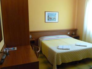 - une chambre avec un lit, une table et un miroir dans l'établissement Bed & Breakfast - Anselmi M&M, à Marciana