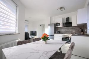 a kitchen with a table with a vase of flowers on it at Apartment Vukadin in Pula