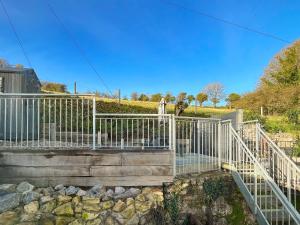 una valla blanca en una escalera con rocas en Stable Cottage, en Penally