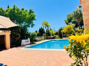una piscina en un patio con árboles y un cielo azul en Villa con piscina gigante, en Sant Francesc de s'Estany