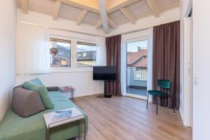 a living room with a couch and a tv at Minerva Guesthouse in Trento
