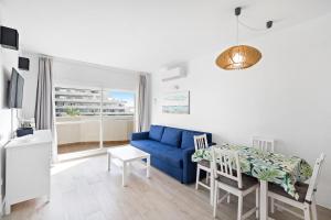 ein Wohnzimmer mit einem blauen Sofa und einem Tisch in der Unterkunft Benalbeach Sea View in Benalmádena