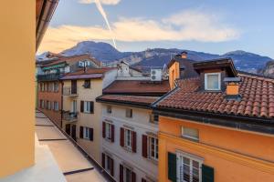 a view of roofs of buildings with mountains in the background at Minerva Guesthouse in Trento