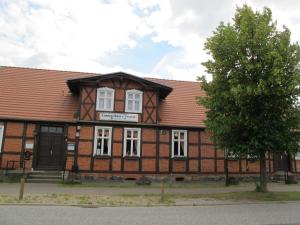 ein Gebäude mit einem Baum davor in der Unterkunft Landgasthaus & Pension Liebner-Land Brandenburg-Prignitz in Groß Pankow