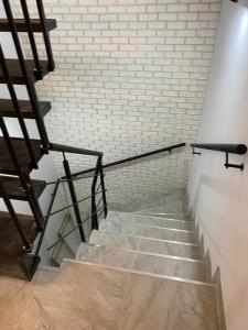 - un escalier dans une chambre dotée d'un mur en briques dans l'établissement MG Mamaia North Villa, à Mamaia Nord – Năvodari