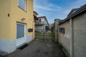 a gate to a building with a door in a driveway at Beat House&Apartments: ABBA in Cernusco sul Naviglio