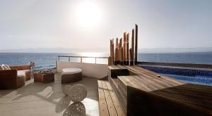 a balcony with a swimming pool and the ocean at Alas Resort & Spa in Elia Laconias