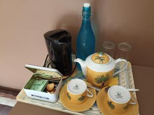 - une table avec deux tasses à thé et une bouteille bleue dans l'établissement Au Coeur d'Acren, à Lessines