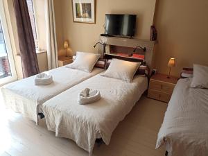 two beds in a bedroom with two hats on them at Au Coeur d'Acren in Lessines