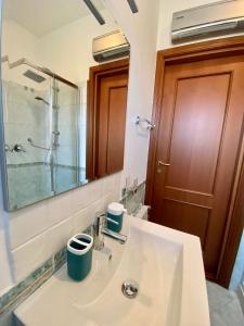a bathroom with a sink and a shower and a mirror at Katrinas Home alloggio turistico in Fiumicino
