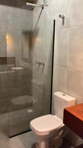 La salle de bains est pourvue de toilettes et d'une douche en verre. dans l'établissement Lyttos Bungalows, à Icapuí