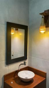 a sink in a bathroom with a mirror and lights at Lyttos Bungalows in Icapuí