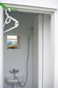 W łazience znajduje się prysznic i biała umywalka. w obiekcie GPtents in SPA w mieście Spa