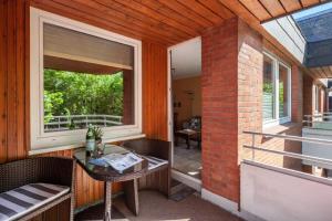 d'une terrasse avec une table, des chaises et une fenêtre. dans l'établissement Haus Meeresgruß, Appartement Flair, à Grömitz