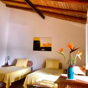 Zimmer mit 2 Betten und einer Vase mit Blumen in der Unterkunft Quinta Quinze in Boliqueime