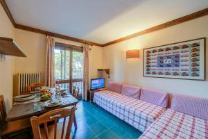 a living room with a couch and a table at Grange Hike & Ski Sestriere Apartments - Happy.Rentals in Sestriere