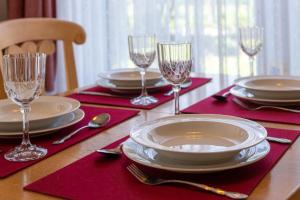 a table with plates and glasses on a table with red napkins at Ferienhaus Seewind 11/1 in Werdum