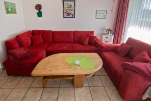 a living room with a red couch and a coffee table at Ferienhaus Seewind 11/1 in Werdum