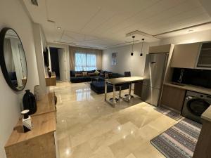 Una cocina y una sala de estar con una mesa y un sofá. en Le LUXE EN BORD DE MER, en Tánger