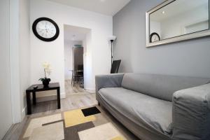 a living room with a couch and a clock on the wall at Cosy 2 Bed Flat 1 in Bridgend in Bridgend