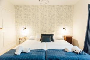 ein Schlafzimmer mit einem großen Bett mit zwei Handtüchern darauf in der Unterkunft O&L Aire - Spacious and Bright Apartment in the Heart of Seville in Sevilla