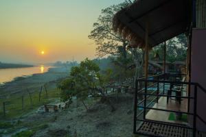 a view of a river with the sunset in the background at Bamby Chilling House in Sauraha
