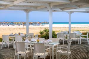 a restaurant with tables and chairs on the beach at The Mirage Resort & SPA in Hammamet