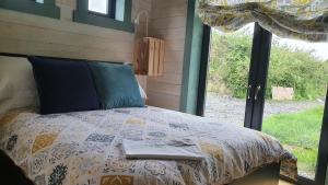 Bett in einem Zimmer mit Fenster in der Unterkunft Pure Space in Kilkee