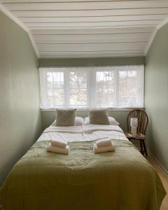 - une chambre avec un grand lit et 2 serviettes dans l'établissement Portør Pensjonat, à Kragerø