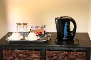 a table with a tray with a black coffee pot and plates at Room in Guest room - Brooklyn Guesthouses in Pretoria