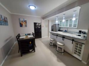 a kitchen with a sink and a counter with stools at Suite at the Courtleigh Towers in Kingston