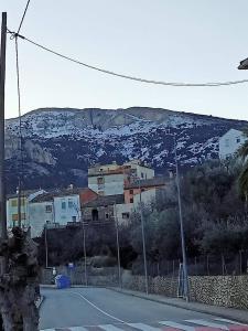 a tennis court with a house on a mountain at Habitacion de la marquesa in Alcoleja