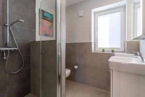 Un baño con ducha, lavabo e inodoro. en Dorfplatz Appartement Dorfplatz, en Olsdorf 22 fotos más