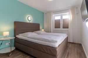 Un dormitorio con una cama grande y una ventana. en Dorfplatz Appartement Dorfplatz, en Olsdorf
