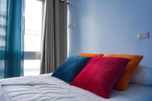 un letto con un cuscino colorato e una finestra di Blue Batayola Pool a Candelaria