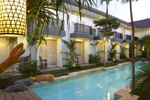 una piscina frente a un edificio con palmeras en 7 Bidadari Hotel Seminyak, en Seminyak 17 fotos más