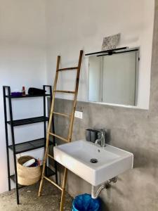a bathroom with a sink and a ladder and a mirror at Summer house Spiti Pirgos in Epanomi