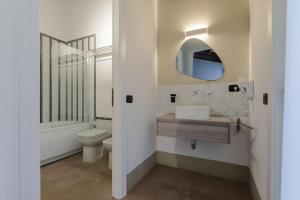 W łazience znajduje się toaleta, umywalka i lustro. w obiekcie Palazzo Cavarretta - Pinella's Rooms and Apartment w mieście Palermo +37 zdjęć