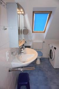 a bathroom with a sink and a toilet and a window at Robbeninsel in Norden