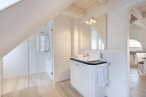 a white bathroom with a sink and a shower at Lister Kaiser in List +33 photos
