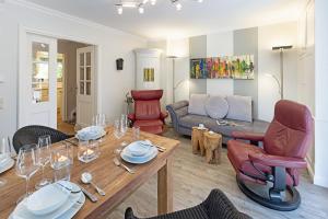 a living room with a table and chairs and a couch at Fischers Koje in List