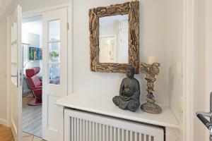 a mirror and a statue on a counter in a room at Fischers Koje in List