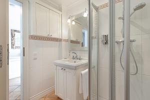 a white bathroom with a sink and a shower at Fischers Koje in List +55 photos