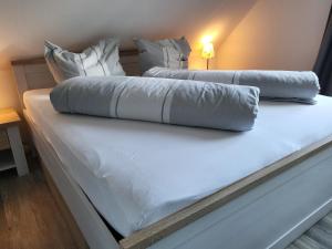 dwa łóżka z białą pościelą i poduszkami na nich w obiekcie Ferienwohnung 3 in der Waldstraße w mieście Sankt Peter-Ording