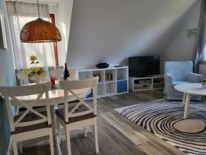 a living room with a table and a tv at Ferienwohnung 4 in der Waldstraße in Sankt Peter-Ording