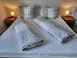 a large white bed with two pillows on it at Ferienwohnung 4 in der Waldstraße in Sankt Peter-Ording